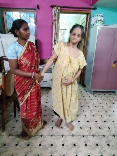 A Soendri caregiver helping an elderly woman walk at home